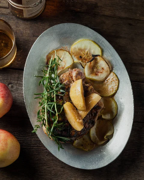 Costeleta de porco grelhada com maçãs de bordo temperadas bourbon servidas com batatas — Fotografia de Stock