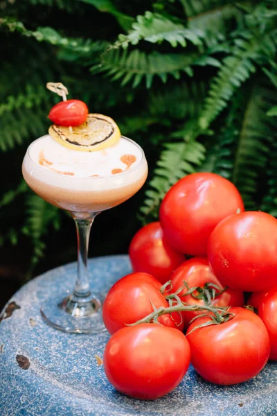 Um coquetel alcoólico com espuma de ovo decorado com um tomate de uva — Fotografia de Stock