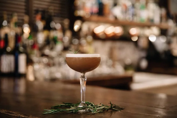 Um cocktail de café cremoso com um bar no fundo — Fotografia de Stock