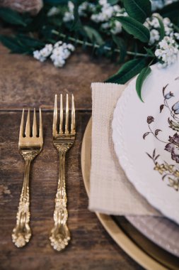 Eski plakalı, taşralı düğün masası, yeşil ve beyaz okaliptüs çelenk, altın kaplar. Boho tarzı. Bir etkinlik, parti, tarih ya da düğün için masa hazır.