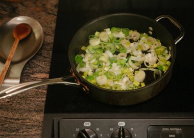 Fırındaki tavada sotelenmeye hazır taze kesilmiş pırasa.