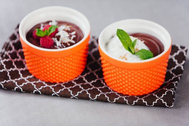 Çikolatalı mus, taze ahududu ve hindistan cevizi gevreğiyle servis edilir.