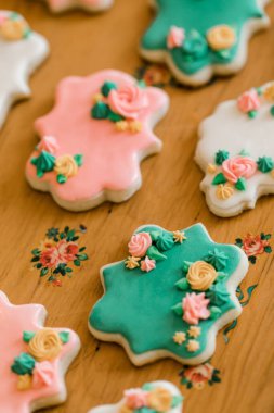 Eski ahşap tepside yeşil, pembe ve beyaz vanilyalı kurabiyeler.