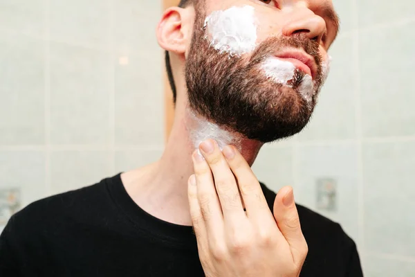 Man puts shaving foam on his face. — Stock Photo, Image