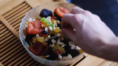 male hand takes nuts from a plate