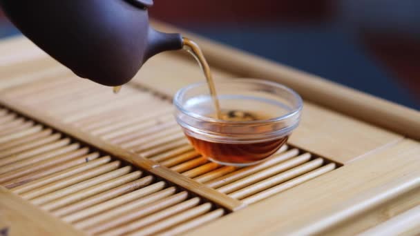 Chinese tea ceremony male hand pours tea into a clay pot from a clay teapot — Stok video