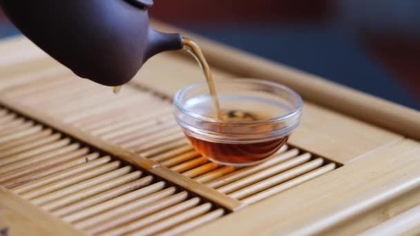 Čínský čajový obřad mužská ruka nalévá čaj do hliněného hrnce z hliněné konvice