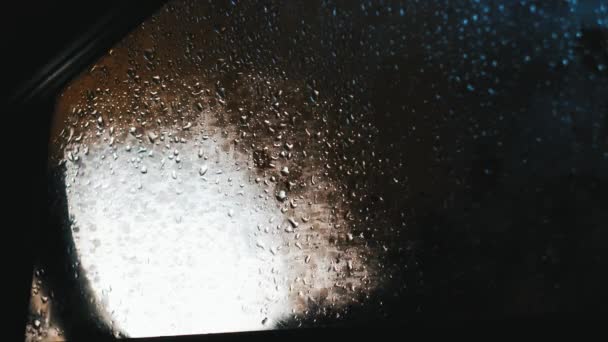 Відображення автомобільних фари в дзеркалі заднього виду з краплями — стокове відео