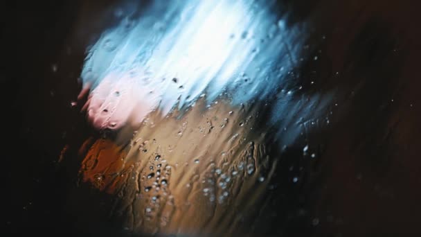 Dripping drops and snow on the windshield of a car against the backdrop — Stok video