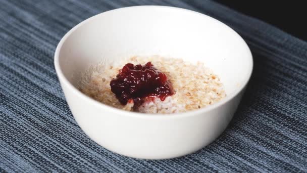 Breakfast oatmeal with lingonberry jam — Stock Video