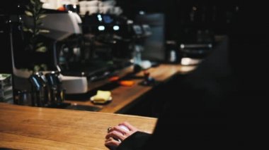 Barista turns on the music on the phone and turns on the light 