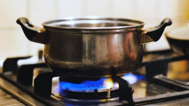 Gaz ocağında tavayla birlikte. Yemekler küçük tavada pişiyor, parlak tarafı açık gaz ocağında.