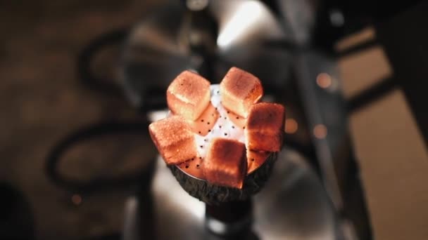 Shisha narguilé charbons chauds rouges, l'homme souffle sur un charbon, étincelles volent. Mouvement lent .