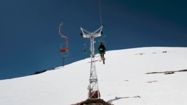 Sciovia rosso sullo sfondo di montagne innevate scende — Video Stock