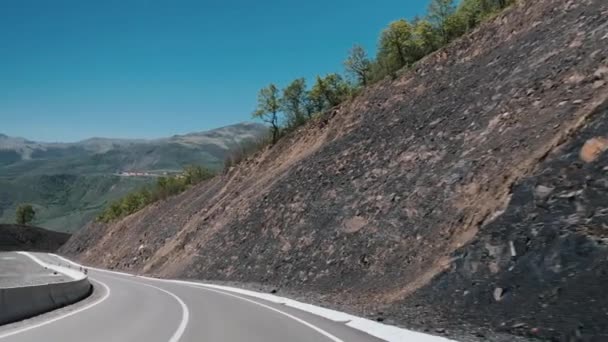 Vista aérea de un coche conduciendo por las tierras altas — Vídeos de Stock