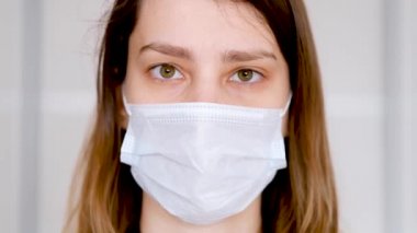 Close-up of a young woman in a protective medical mask