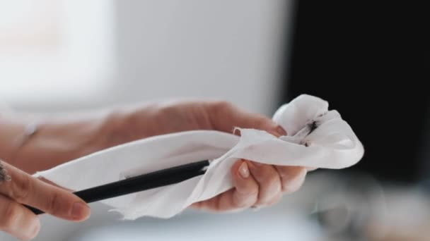 A menina limpa um pincel de tinta oleosa suja em um pano branco . — Vídeo de Stock