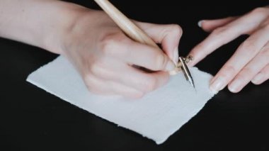 Kaligrafi sözcüğündeki harfleri italik harflerle gösteren kız elleri