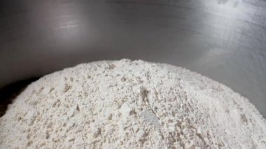 girl cook picks flour from aluminum utensils