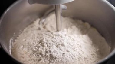 mixer mixes eggs with flour in a factory