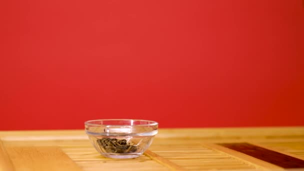 Vierta el té chino en un recipiente de vidrio en una bandeja de madera - pastor — Vídeos de Stock