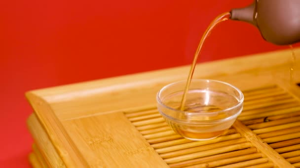Versare il tè da una teiera di terracotta in ciotole . — Video Stock