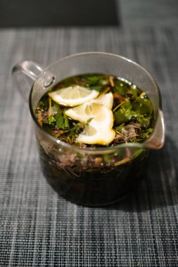 Bardaktaki çaydanlıkta limonlu bitki çayı.