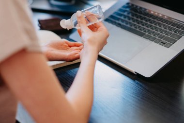 Freelancer el jeli sıkar. Kız el jölesini dezenfekte eder