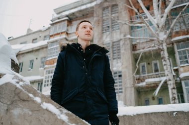 Terk edilmiş bir evin arka planındaki adam.