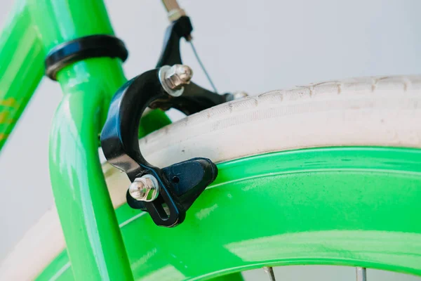 Тормоза зеленого фиксирующего велосипеда с белыми шинами — стоковое фото