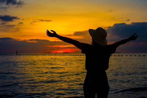 Silhouette women wearing a hat are enjoying a beautiful sunset o — Stock Photo, Image