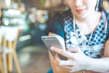Kadın el cep telefonları müzik dinliyor.