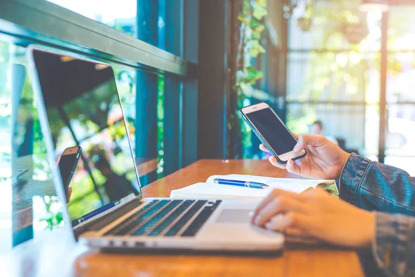 Kadın el bir cep telefonu kullanır ve bir dizüstü bilgisayarda adresinde bulunan İnşaat.