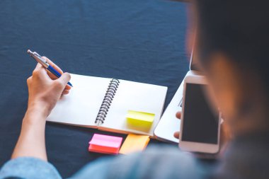 Kadın el bir not defterinde ofiste kalemle yazma.