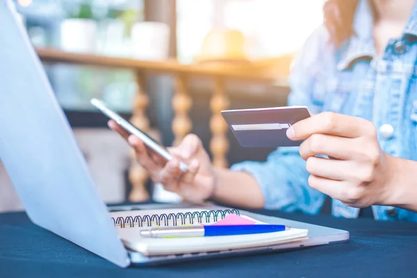 Kadınlar kredi kartları tutmak ve online alışveriş için cep telefonu kullanımı