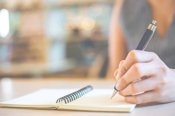 Egy üzletasszony keze tollal ír egy jegyzetfüzetre.. — Stock Fotó