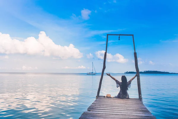 Moře a jasná obloha. Den se sedící turistkou. — Stock fotografie