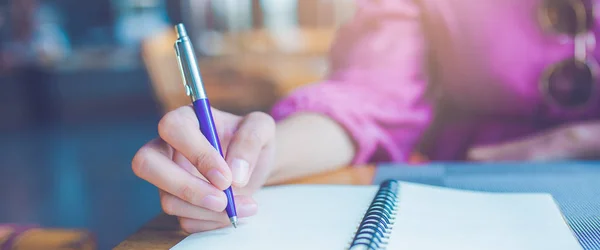 Frau macht sich mit Stift Notizen auf Notizbuch. — Stockfoto