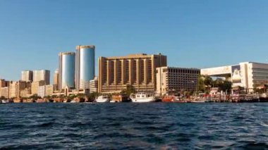 Küçük ahşap bir feribotla Deira Main Abra istasyonuna giden POV zaman tüneli Dubai Creek boyunca ilerler..