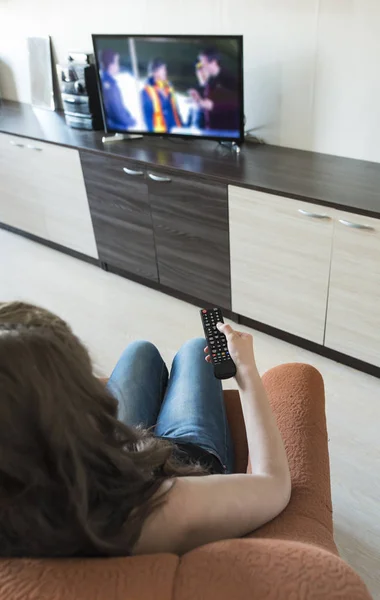 Woman hold TV remote control.