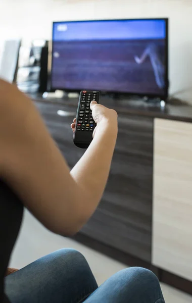 Woman hold TV remote control.