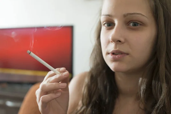 Meisje rook sigaret in het huis. — Stockfoto