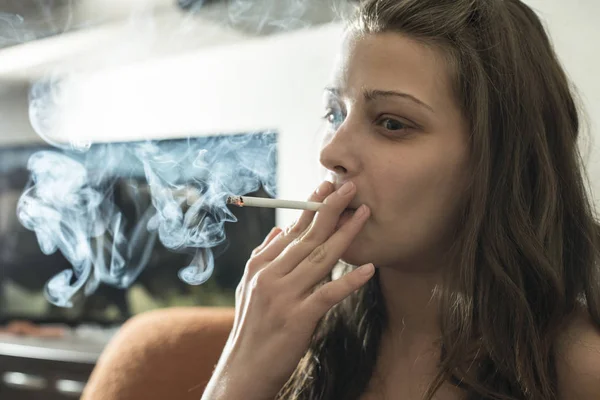 Fata fumeaza tigara in casa . — Fotografie, imagine de stoc