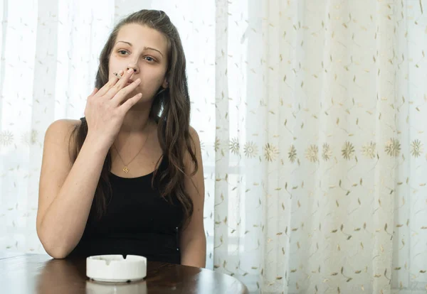 Chica fuma cigarrillo y sostiene cenicero . — Foto de Stock