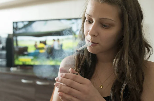 Νεαρή γυναίκα ανάβει ένα τσιγάρο. — Φωτογραφία Αρχείου