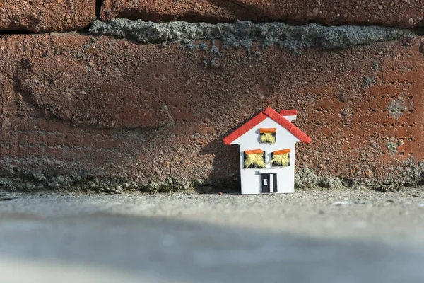 Hausminiatur und Ziegelmauer — Stockfoto