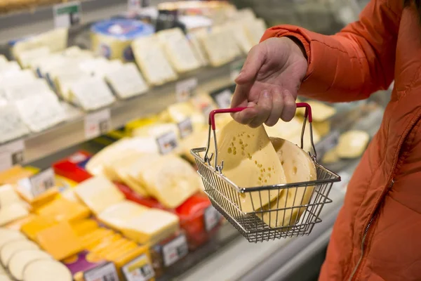 Cheese in supermarket. Buying cheese in shop.