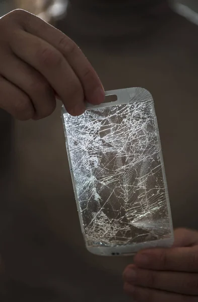 Hands holding a broken screen of smartphone