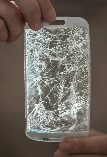 Hands holding a broken screen of smartphone