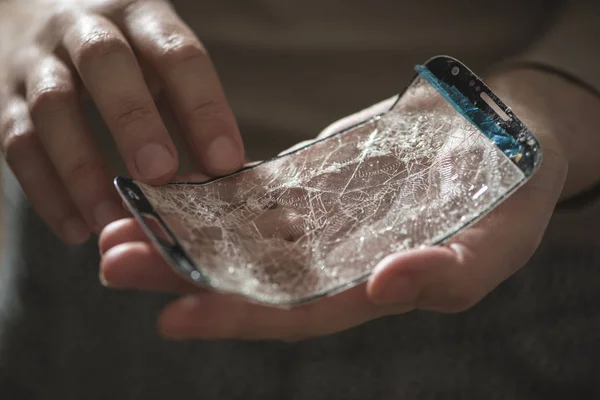 Hands holding a broken screen of smartphone